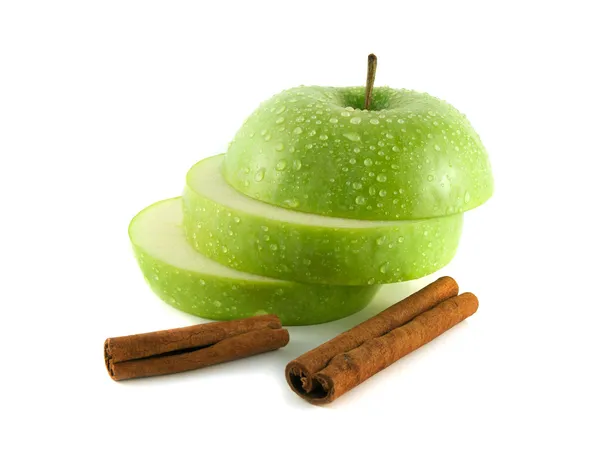 Isolierte grüne Apfelscheiben mit Zimtschoten — Stockfoto