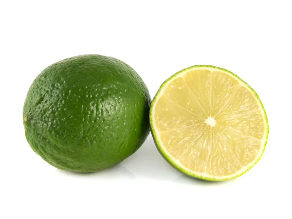 Isolierte grüne Limette mit halb geschnittenen Scheiben auf einem weißen — Stockfoto