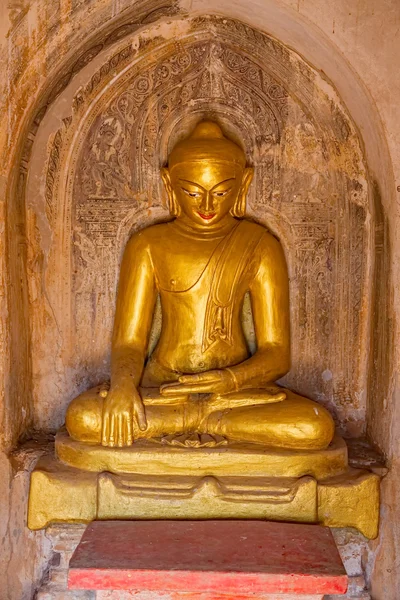 Old renovated sculpture of a golden seated Buddha — Stock Photo, Image