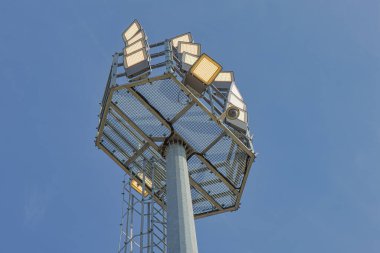 Mavi gökyüzüne karşı bir direkte lamba yaktı.