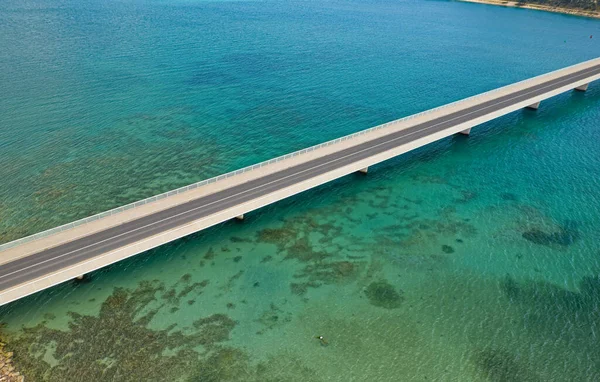 Aerial top view of a long bridge above a sea — Stock Photo, Image
