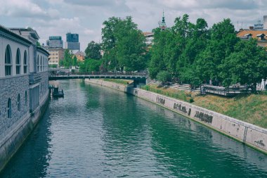 LJUBLJANA, SLOVENIA - AUGUST 25 2022: River Ljubljanica bank with Butchers Bridge in old city center