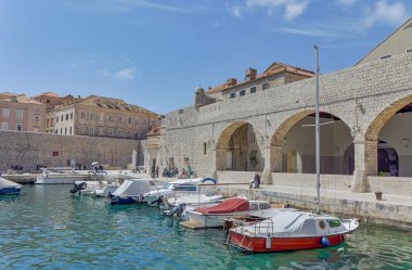 DUBROVNIK, CROATIA - APRIL 26 2022: The old town harbor atmosphere with local small boats moored