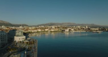BÖLÜM, CROATIA - 16 Ocak 2022: Bir martı eski tarihi şehir ve Diocletian sarayının günbatımındaki panoramik görüntüsü sırasında kameranın önünden geçer.