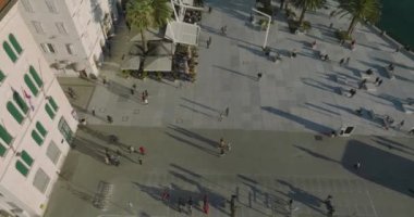 BÖLÜM, CROATIA - 16 Ocak 2022: Riva gezinti alanı boyunca yürüyen ve gün batımında Diocletians Sarayı 'ndaki eski kasabanın merkezindeki kafelerin keyfini çıkaran insanların hava görüntüleri.