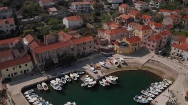 SALI, CROATIA - 22 Mart 2022: Dugi Otok adasındaki tipik bir Dalmaçya adasında demirlemiş balıkçı tekneleriyle küçük limanın havadan görünüşü.