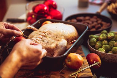 İnsanın ev mutfağında lezzetli ve sağlıklı bir Noel ördeği hazırlarken çekilmiş görüntüsü.