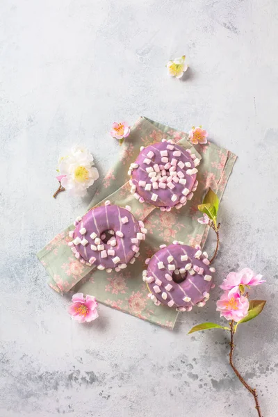 Lahodné Barevné Glazované Koblihy Růžové Kvetoucí Jarní Květiny Šedém Pozadí — Stock fotografie