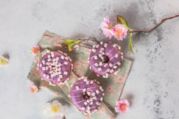 Nahaufnahme Von Köstlichen Bunten Glasierten Donuts Und Rosa Blühenden Frühlingsblumen — Stockfoto