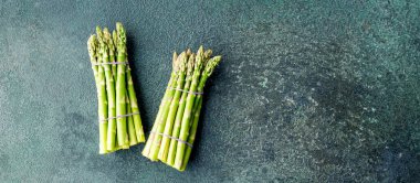 Köy arka planında bir sürü yeşil kuşkonmaz, çiftçi pazarında taze çiftlik sebzeleri.