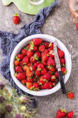 Koyu renkli taş masadaki olgun çilekler..