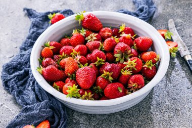 Koyu renkli taş masadaki olgun çilekler..