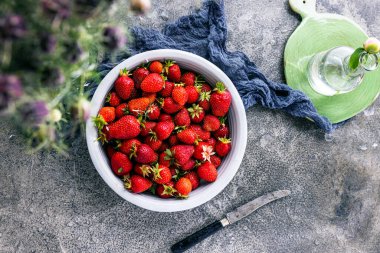 Koyu renkli taş masadaki olgun çilekler..