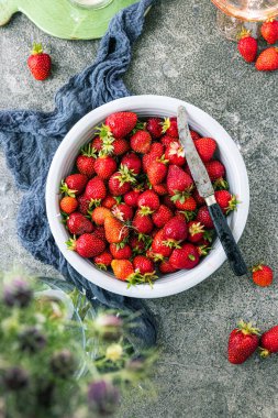 Koyu renkli taş masadaki olgun çilekler..