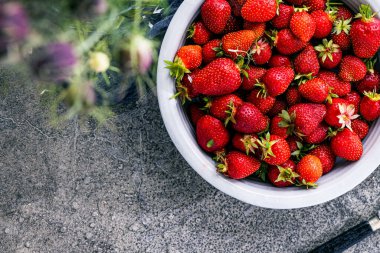 Koyu renkli taş masadaki olgun çilekler..