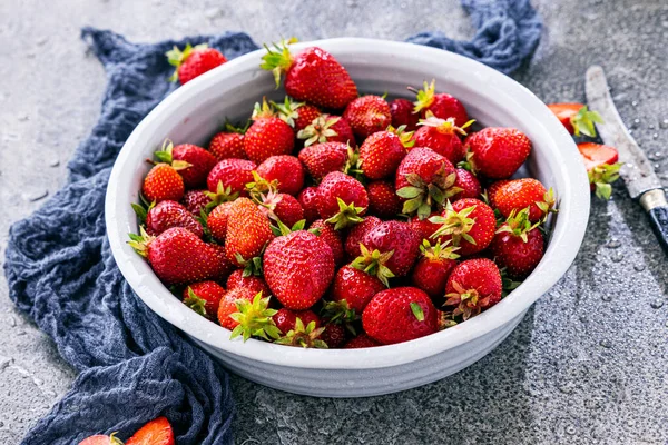 Koyu renkli taş masadaki olgun çilekler..