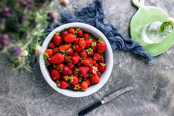 Koyu renkli taş masadaki olgun çilekler..
