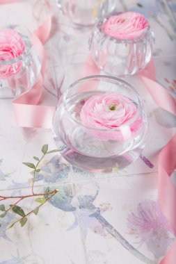 rose flowers in the glasses with pink ribbon. Floral background