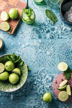 Taze mojito kokteyli, limonlu, naneli ve buzlu kavanozlu koyu mavi arka planda.