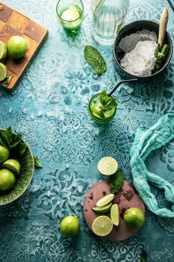 Taze mojito kokteyli, limonlu, naneli ve buzlu kavanozlu koyu mavi arka planda.