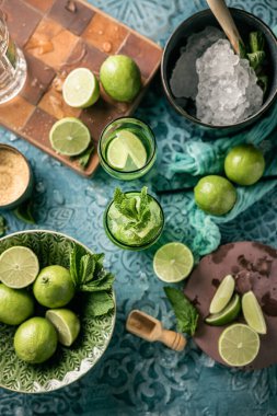 Taze mojito kokteyli, limonlu, naneli ve buzlu kavanozlu koyu mavi arka planda.