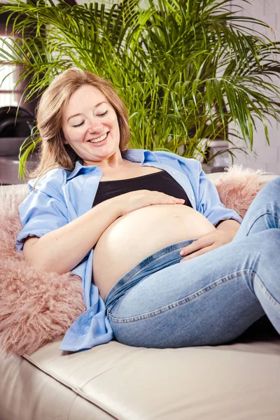 Beautiful Pregnant Woman Sitting Sofa Hugging Her Belly — Stockfoto