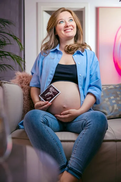 Pregnant Woman Sitting Sofa Holding Ultrasound Picture Unborn Baby — Foto de Stock