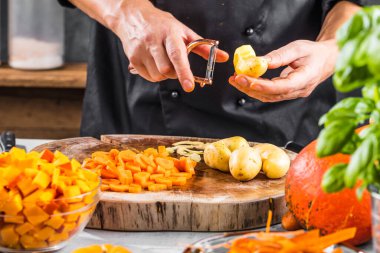 Şefin sağlıklı balkabağı çorbası için organik malzemeler hazırlarken kısmi görüntüsü