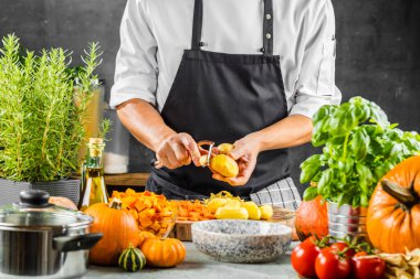 Şefin orta bölümü balkabağı çorbası için taze organik malzemeler hazırlıyor.