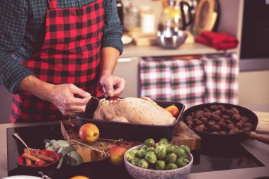 Adam ev mutfağında lezzetli ve sağlıklı bir Noel ördeği hazırlıyor..