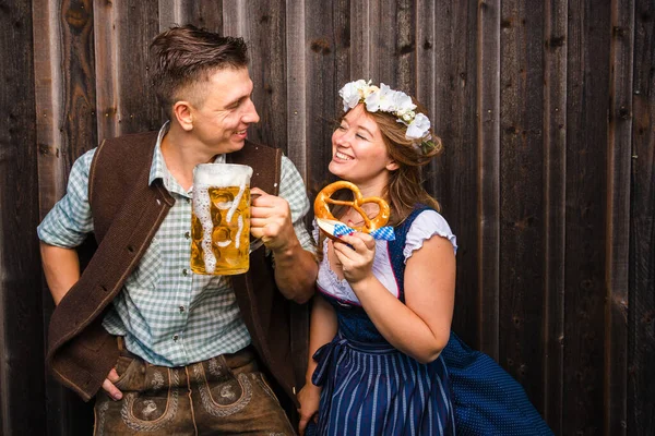 Junge Frau Und Mann Mit Bierglas Und Brezel Auf Holzuntergrund — Stockfoto