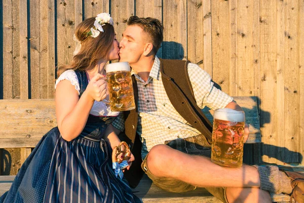 若い女性とビールグラスと木製の背景にキスプレッツェルと男 オクトーバーフェストのコンセプト — ストック写真