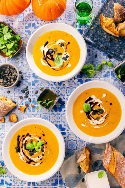 Pumpkin soup in a bowls with pumpkin seeds and croutons. Fall dinner.