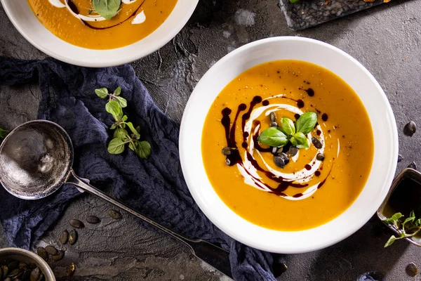 Pumpkin soup in a bowls with pumpkin seeds and croutons. Fall dinner.