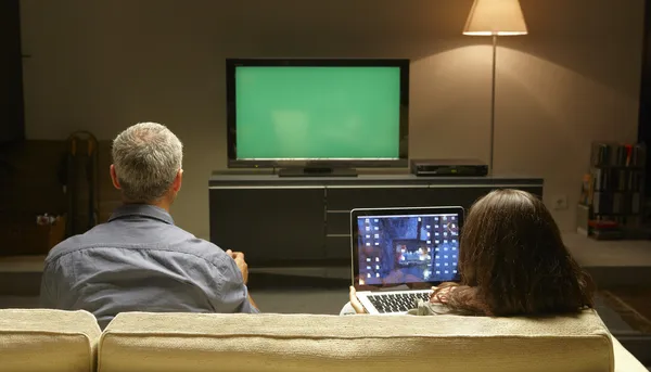 Keski-Aikuiset katsomassa televisiota ja PC tekijänoikeusvapaita valokuvia kuvapankista