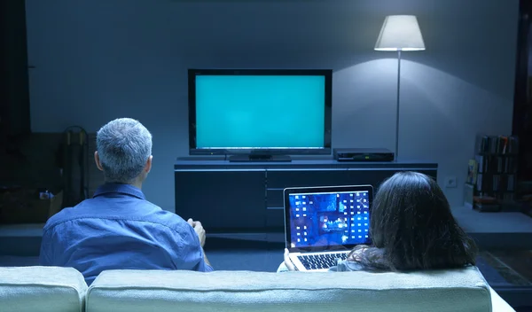 Erwachsene fernsehen und PC Stockbild