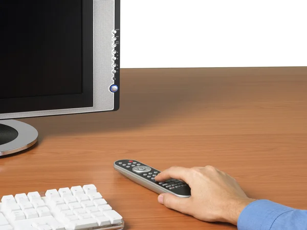 TV monitor, keyboard and hand with remote control — Stock Photo, Image