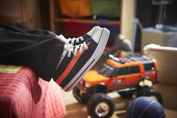 Niño con nuevas zapatillas en la cama —  Fotos de Stock