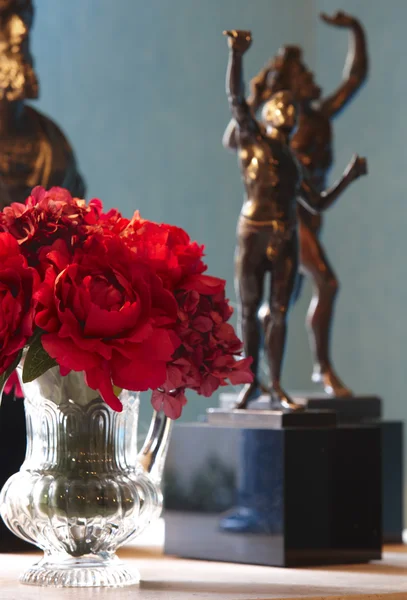 Rote Blumen mit Dekorationsfiguren — Stockfoto