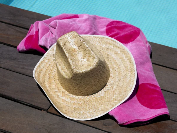 Cappello e telo mare a bordo piscina — Foto Stock