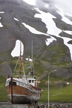 eski balıkçı teknesi ve dağ. İzlanda. Siglufjordur.