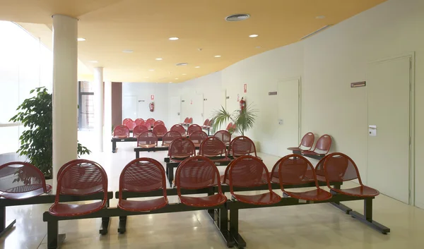 Hospital waiting area with red metallic chairs. — Stock Photo, Image