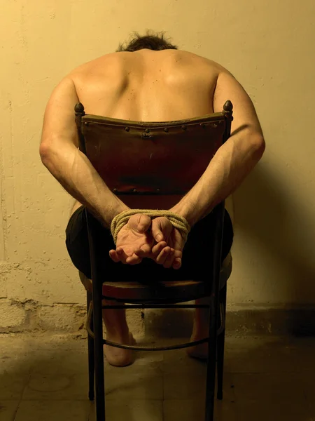 Człowiek tortur na krześle. — Zdjęcie stockowe