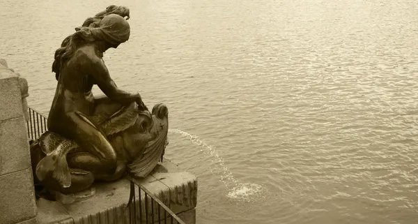 Металлическая скульптура фонтана и озеро в сепии — стоковое фото