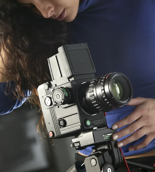 Jovem fotógrafo tirando fotos com câmera e tripé — Fotografia de Stock