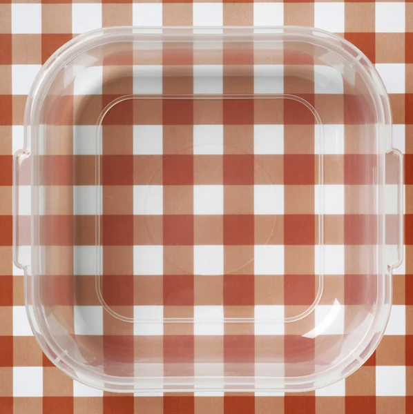 赤と白のテーブル クロスの上のプラスチック包装 — ストック写真