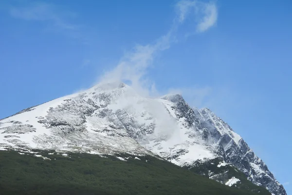 Mountain peak with snow and clouds