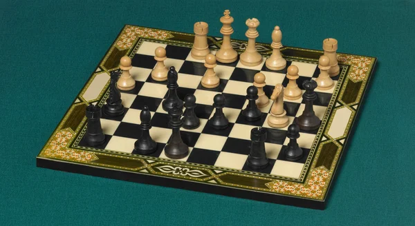 Classic chessboard with pieces over a green background — Stock Photo, Image