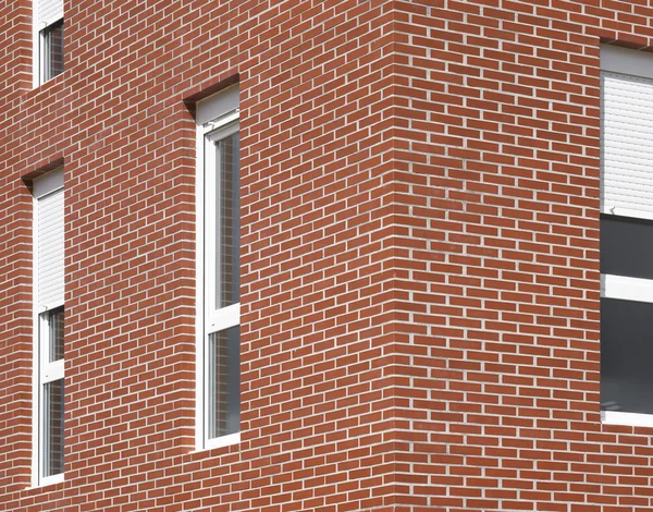 Fachada de edificio con ladrillos rojos y ventanas — Foto de Stock