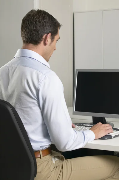 Young man in an office working with a computer — Stock Photo, Image